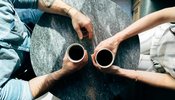 Two people sat with a cup of coffee