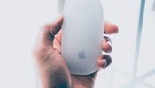 a person holding an apple mouse