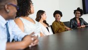 A business meeting with women of different gender and races
