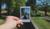 a Polaroid picture being held over a river