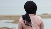 dark haired woman looking out at sea