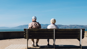 an elderly couple sitting on a bench