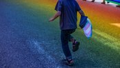 child running in rainbow tinted street