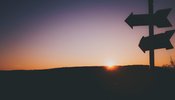 a sign post in a sunset