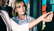 women looking at a post it note board