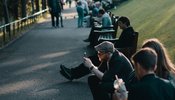 People on their phones on park benches